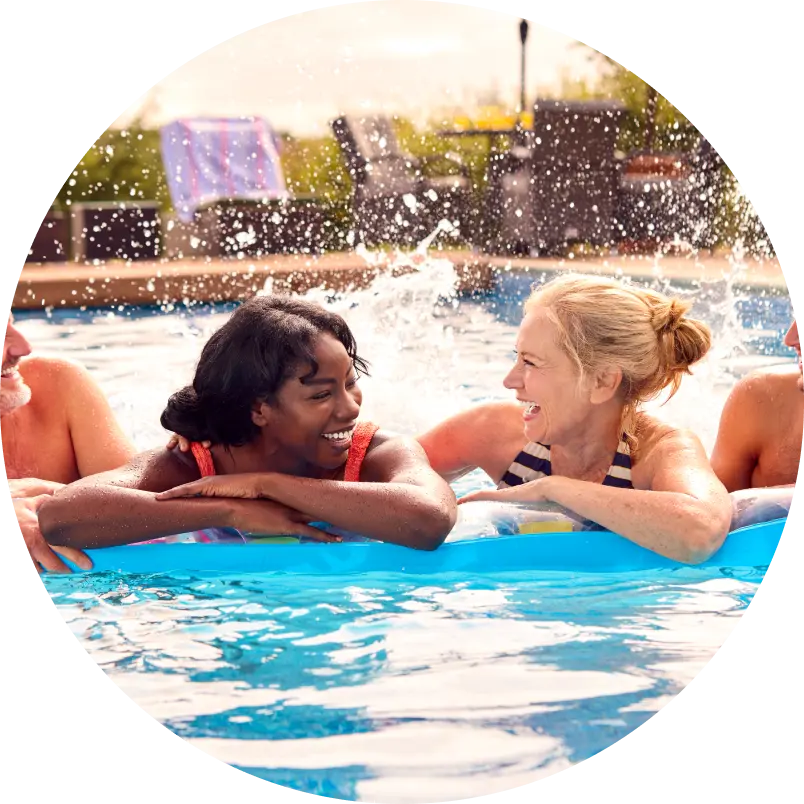 Two smiling women on a float in a pool